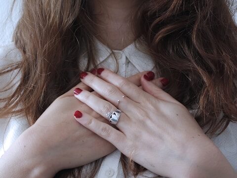 女性が両手を胸に当てている画像